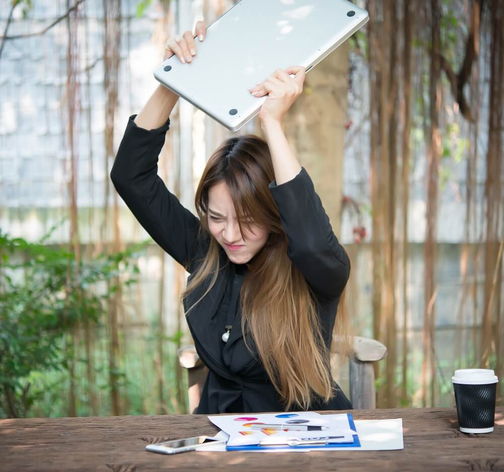 woman angry throwing laptop